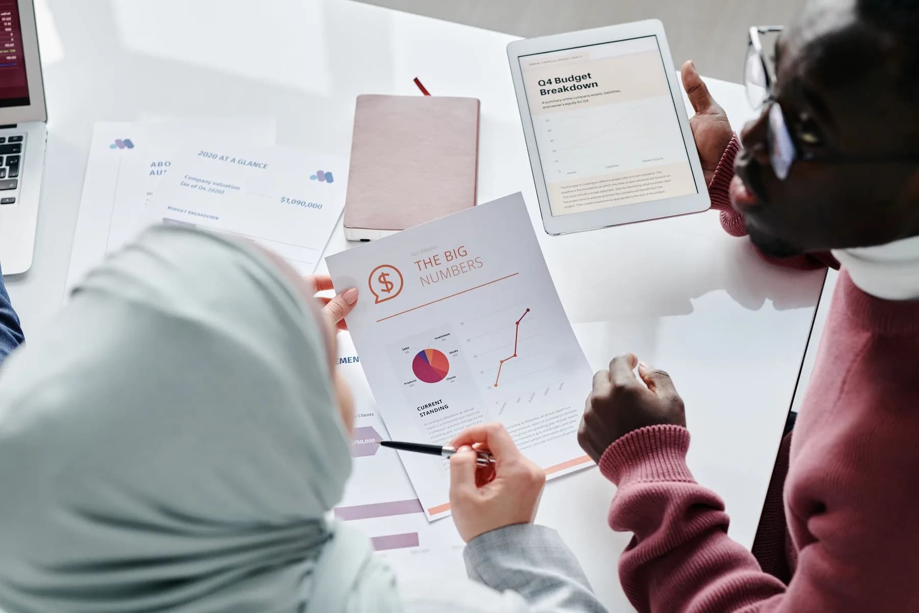 Twee collega’s analyseren cijfers en documenten.